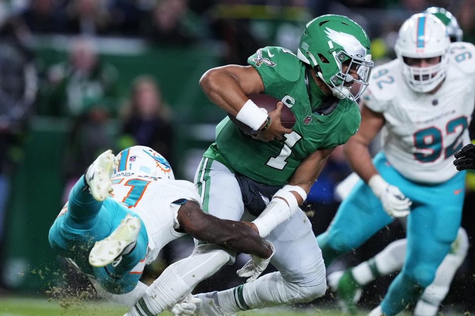 Philadelphia Eagles quarterback Jalen Hurts (1) escapes the tackle from Miami Dolphins linebacker David Long Jr. (51) during the second half of an NFL football game Sunday, Oct. 22, 2023, in Philadelphia. (AP Photo/Matt Rourke)