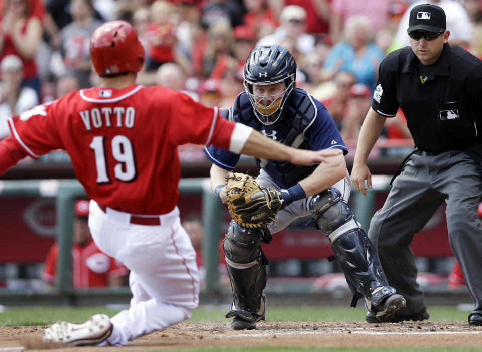 Tampa Bay Rays catcher Ryan Hanigan waits to tag out Cincinnati Reds' Joey Votto (19) at home in the fourth inning of a baseball game, Saturday, April 12, 2014, in Cincinnati. Votto was trying to score on a hit by Brandon Phillips. Umpire Clint Fagan watches. (AP Photo/Al Behrman)