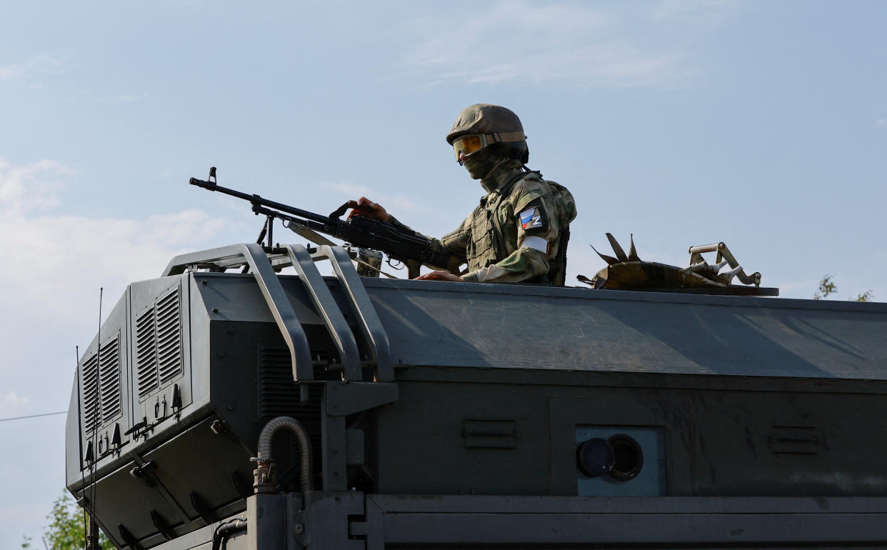 A Russian service member holds a weapon on the top of a military vehicle in the course of Ukraine-Russia conflict in the Russian-controlled city of Enerhodar in the Zaporizhzhia region, Ukraine September 1, 2022. REUTERS/Alexander Ermochenko