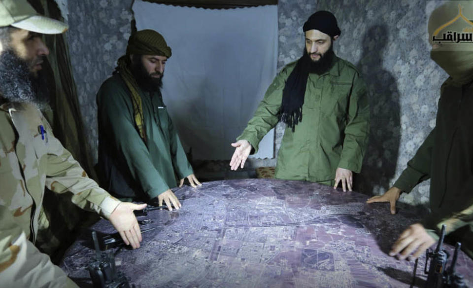 FILE - This undated photo released by a militant group in 2016 shows Abu Mohammed al-Golani, of the Levant Liberation Committee and the leader of Syria's al-Qaida affiliate, second from right, discussing battlefield details with field commanders over a map, in Aleppo, Syria. Syria’s civil war has entered its 14th year on Friday March 15, 2024, a somber anniversary in a long-frozen conflict. The country is effectively carved up into areas controlled by the Damascus government, various opposition groups and Kurdish forces. (Militant UGC via AP, File)