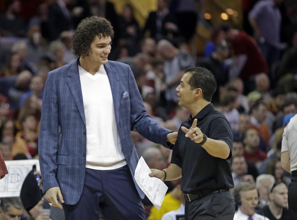 Injured Cleveland Cavalier Anderson Varejao, left, talks with trainer Michael Mancias during an NBA basketball game against the Philadelphia 76ers Monday, Feb. 2, 2015, in Cleveland. (AP Photo/Mark Duncan)