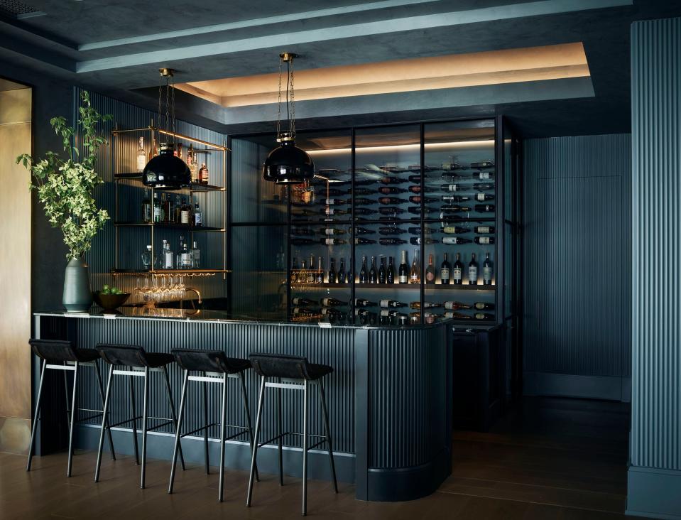 Seiders painted the bar in Farrow and Ball’s De Nimes and Railings shades of blue. The barstools, which have charcoal cowhide seats, are from Thomas Hayes Studio. The hand-blown glass pendants are from Roman and Williams Guild.