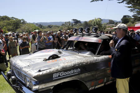 Master of ceremonies, Alan Galbraith presents the "Worst of Show" to a 1964 Ford Fairline at the Concours d'Lemon, part of the Pebble Beach Concours d'Elegance in Seaside, California, August 15, 2015. REUTERS/Robert Galbraith