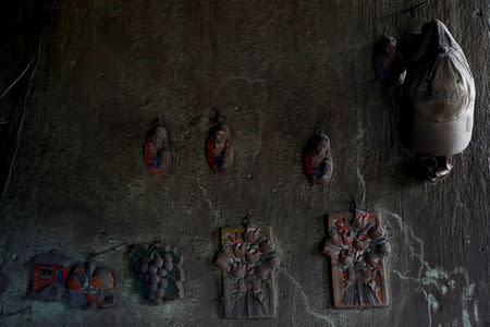 Wall decorations covered with ash hang in a house affected by the eruption of the Fuego volcano at San Miguel Los Lotes in Escuintla, Guatemala, June 8, 2018. REUTERS/Carlos Jasso