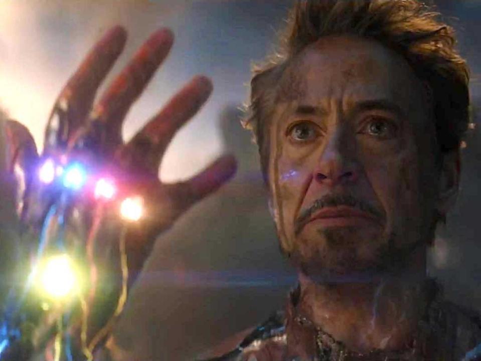 Robert Downey Jr. as Iron Man, holding up a gauntlet with six stones, in "Avengers: Endgame."