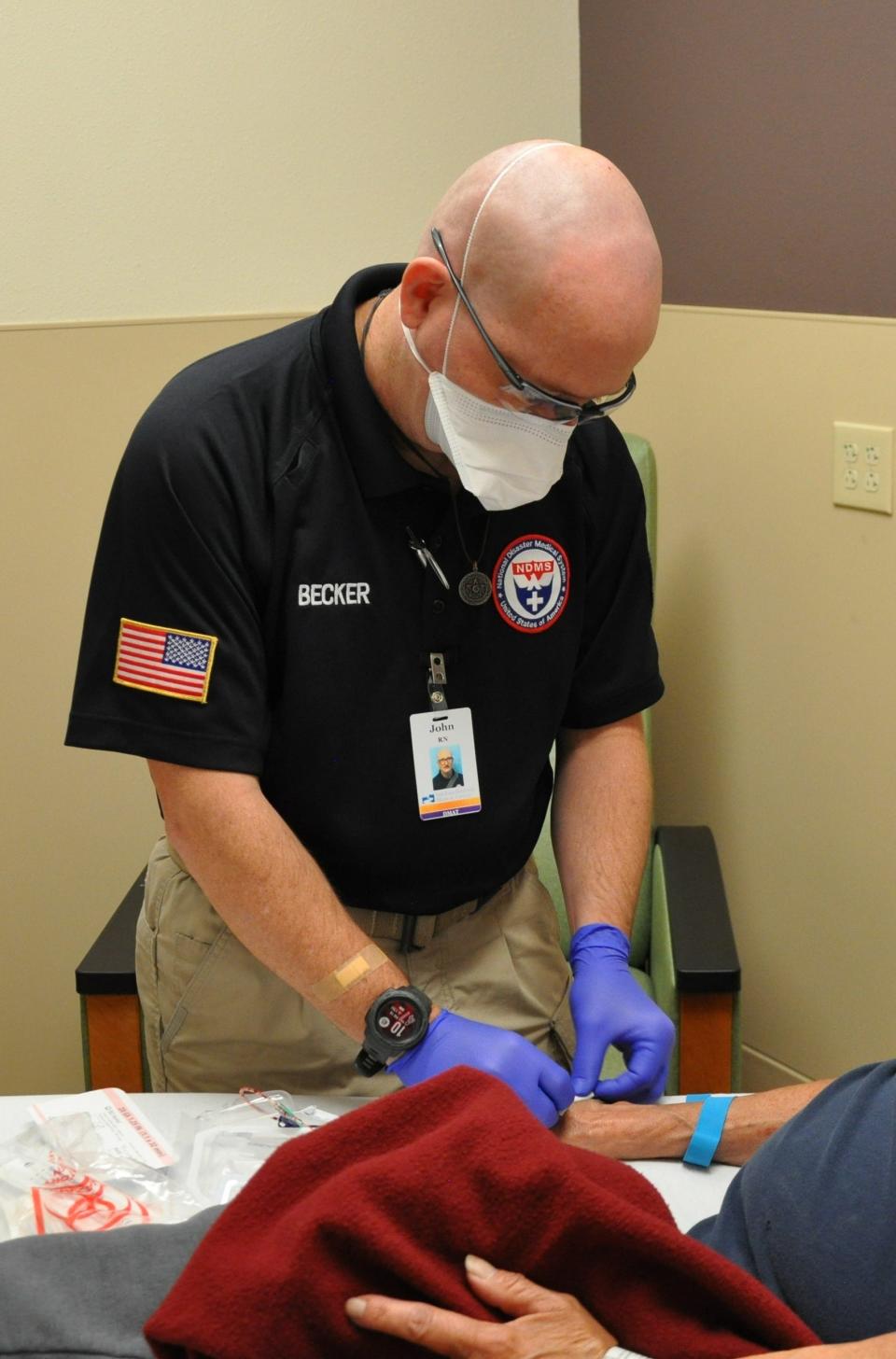 Registered nurse J.J. Becker checks on a patient at the San Juan Regional Medical Center Nov. 19 during his deployment to the facility as part of a disaster medical assistance team from Ohio.