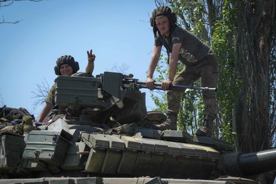 Soldiers sit atop a tank in the Donetsk region. To boost its war efforts, the government has banned men ages 18 to 60 from leaving the country in case it needs to start a draft. (Efrem Lukatsky / AP)