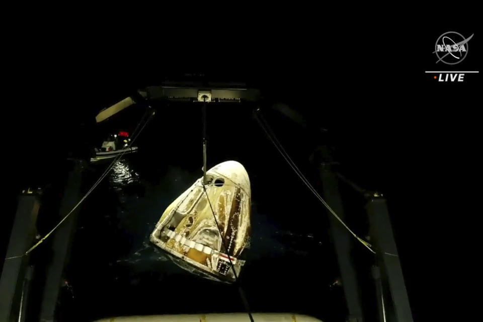 In this image made from video supplied by NASA, SpaceX Dragon space capsule is lifted out of the water after splashing down in the Gulf of Mexico early Friday, May 6, 2022. NASA’s Raja Chari, Tom Marshburn and Kayla Barron, and the European Space Agency’s Matthias Maurer undocked from the International Space Station less than 24 hours earlier. (NASA via AP)