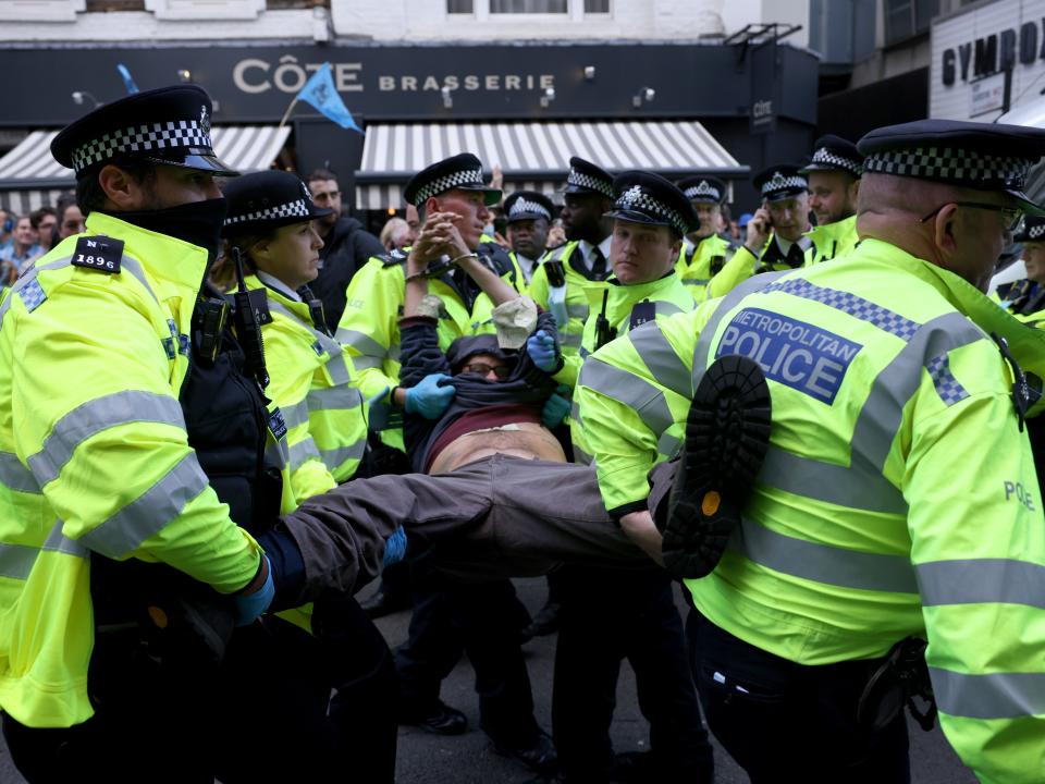 An XR protester, who installed himself on top of a van, is arrested at the group’s first day of protesting in Covent Garden (Getty)