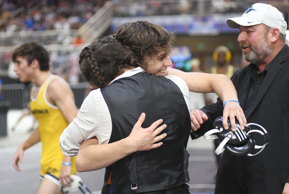 Bartram Trail's Ethan Vugman hugs technical coach Evan McCall as head coach Chad Parker joins the celebration of Vugman's 2-1 victory over Steinbrenner's Colin Bradshaw in the Class 3A 126-pound final Saturday, March 4, 2023, at the FHSAA State Wrestling Championships at the Silver Spurs Arena in Kissimmee.