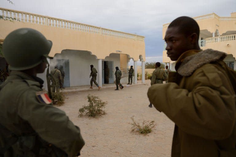 Malian soldiers enter a house which was held by Islamists, after Malian and French soldiers entered the historic city of Timbuktu, on January 28, 2013