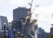 Two large cranes from the Hard Rock Hotel construction collapse come crashing down after being detonated for implosion in New Orleans, Sunday, Oct. 20, 2019. New Orleans officials set off several explosions Sunday intended to topple two cranes that had been looming over the ruins of a partially collapsed hotel. (AP Photo/Gerald Herbert)