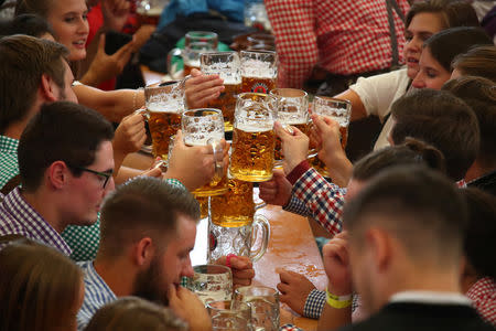 Visitors toast with beers during the opening day of the 185th Oktoberfest in Munich, Germany September 22, 2018. REUTERS/Michael Dalder