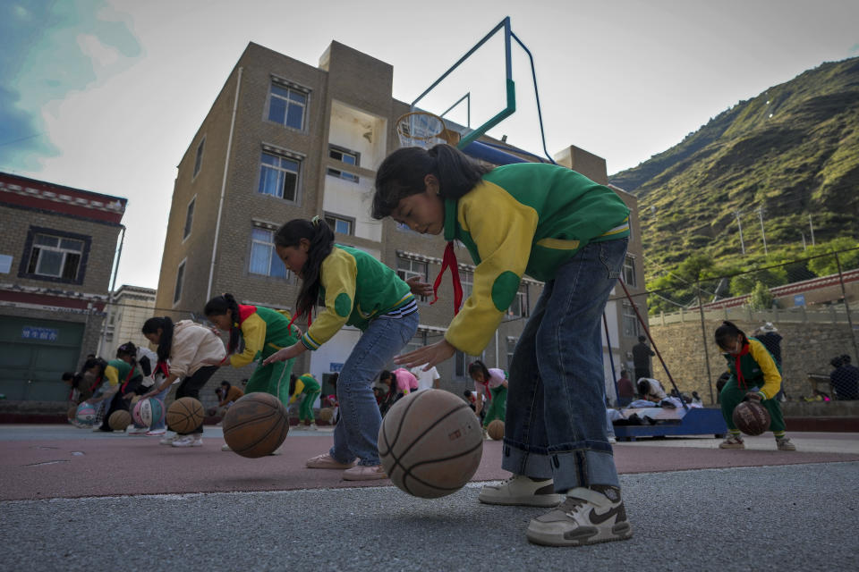 Students play basketballs during a physical education class at the Shangri-La Key Boarding School during a media-organized tour in Dabpa county, Kardze Prefecture, Sichuan province, China on Sept. 5, 2023. (AP Photo/Andy Wong)