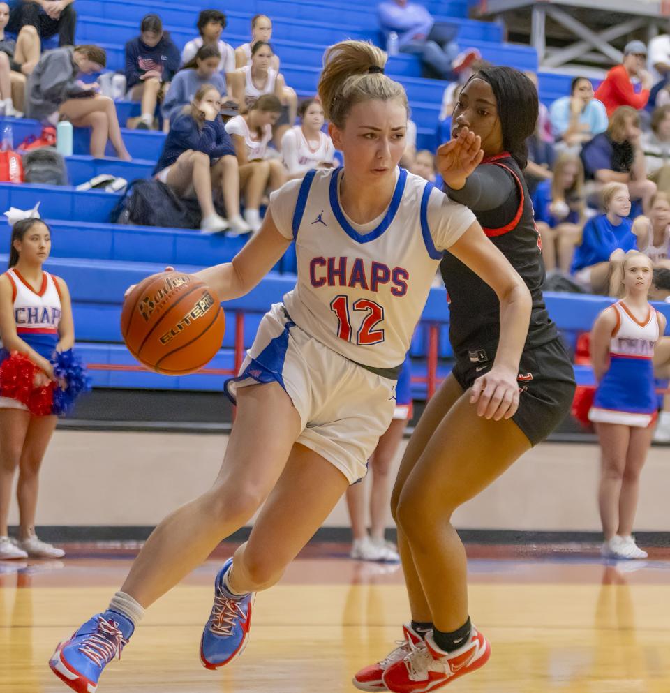 Westlake Chaparrals guard Bella Hesse (12) drives to the basket as Del Valle Cardinals guard Claudia Carr (3) defends during the third period at the District 26-6A girls basketball game on Friday, Dec 8, 2023, at Westlake High School — West Lake Hills, TX.
