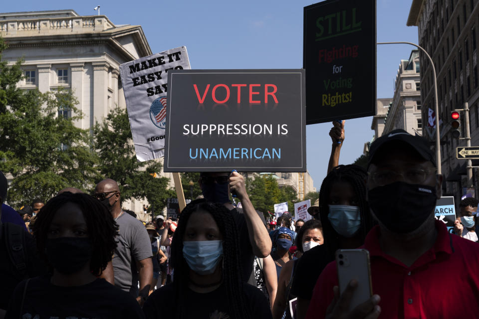 Demonstrators hold signs during a march for voting rights, marking the 58th anniversary of the March on Washington, Saturday, Aug. 28, 2021, in Washington. Hundreds of thousands of voting rights advocates rallied across the country Saturday to call for sweeping protections against a further erosion of the Voting Rights Act of 1965. (AP Photo/Jose Luis Magana)