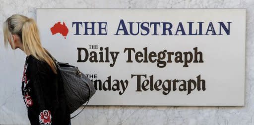 A woman walks past signage outside the entrance to the News Limited building in Sydney on June 20. Rupert Murdoch's News Limited made a $2.0 billion takeover bid for rival tycoon James Packer's majority-owned Consolidated Media Holdings, ahead of a widely expected company restructure