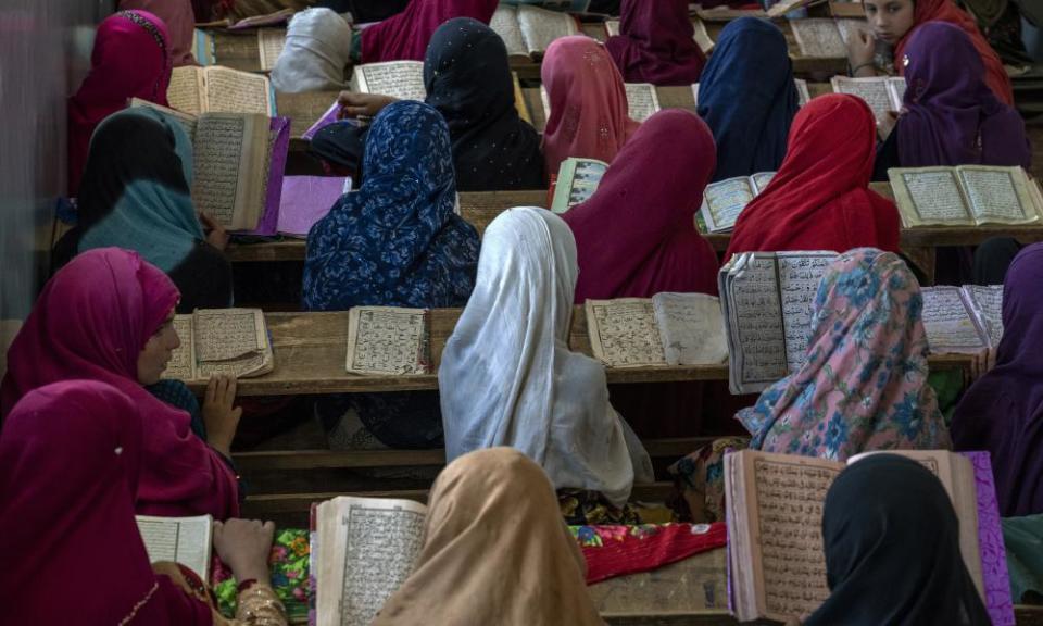Las niñas afganas leer el Corán’an en pupitres en un aula