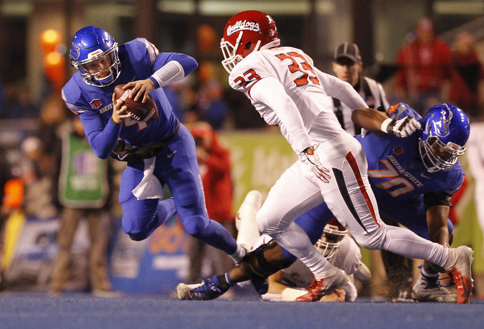 Boise State quarterback Brett Rypien (4) is tripped up by a Fresno State play for a loss during an NCAA college football game Friday, Nov. 9, 2018, in Boise, Idaho. (Drew Nash/The Times-News via AP)