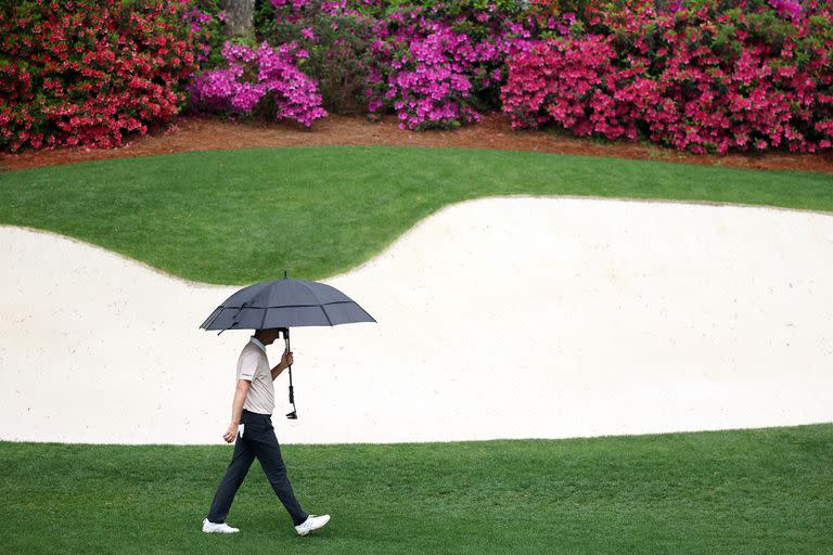 Justin Rose camina con el paraguas, en una jornada interrumpida por la lluvia en Augusta. Candidato a pelear hasta el final.