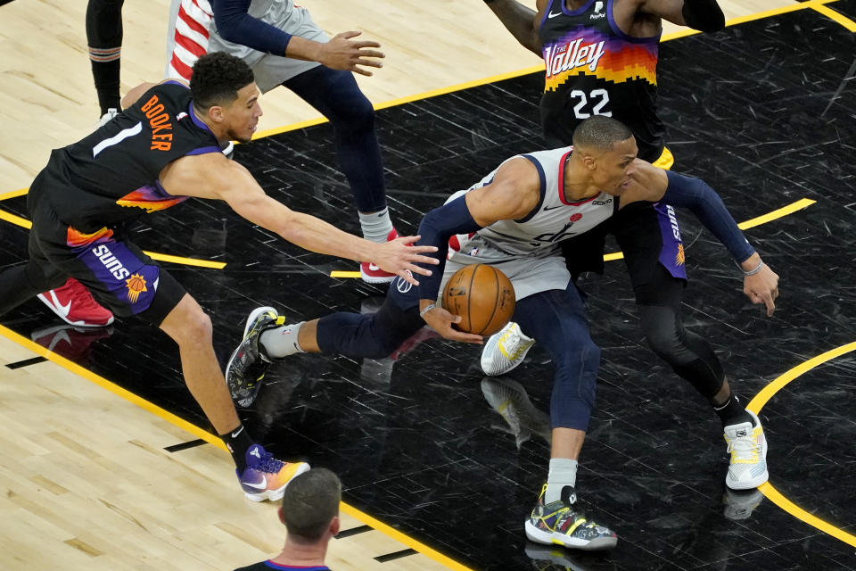 Washington Wizards guard Russell Westbrook drives on Phoenix Suns center Deandre Ayton (22) during the second half of an NBA basketball game, Saturday, April 10, 2021, in Phoenix. (AP Photo/Matt York)