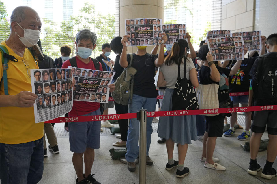 Supporters hold placards with the photos of some of the 47 pro-democracy defendants outside a court in Hong Kong, Thursday, July 8, 2021. A court hearing for 47 pro-democracy activists charged with conspiracy to commit subversion under the security law over their involvement in an unofficial primary election last year that authorities said was a plot to paralyze Hong Kong's government. (AP Photo/Kin Cheung)