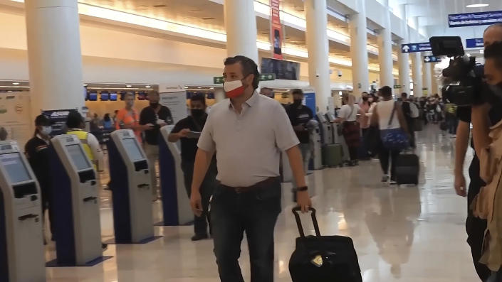 In this image from video, Sen. Ted Cruz, R-Texas, walks to check in for his flight back to the U.S., at Cancun International Airport in Cancun, Mexico, Thursday, Feb. 18, 2021. (AP Photo/Dan Christian Rojas)