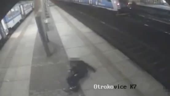 One of the men can be seen withering in pain after the train clipped him on its way past. Photo: LiveLeak