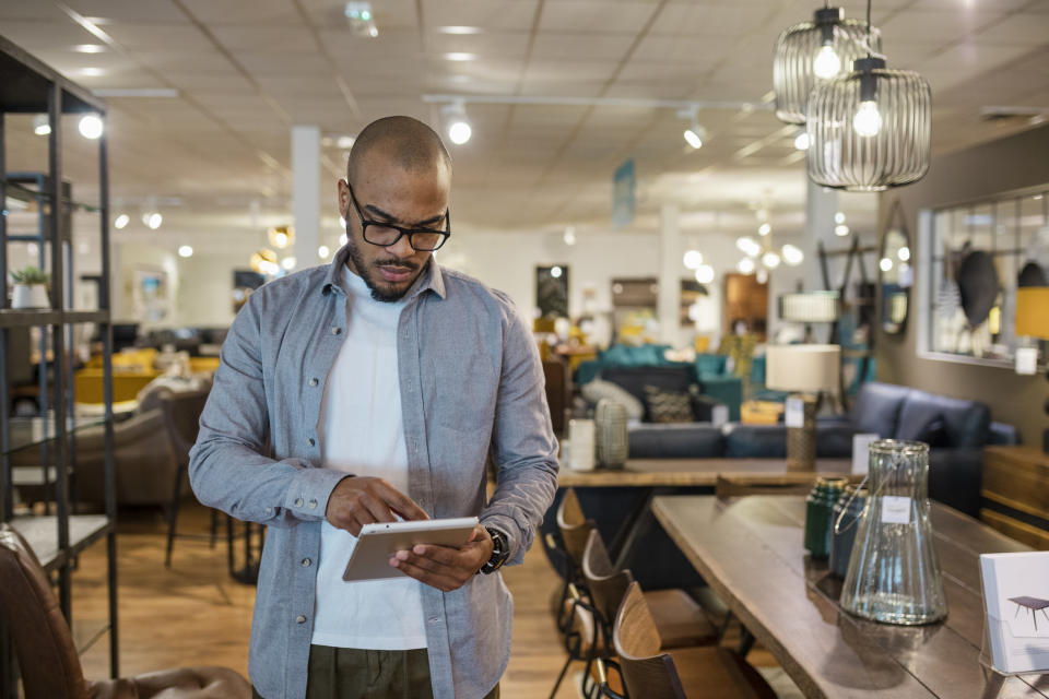 A man using an iPad in a furniture store