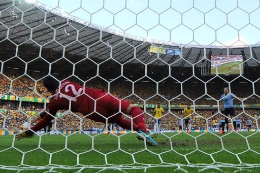 El portero brasileño Julio César contiene un penal al atacante uruguayo Diego Forlán, en partido semifinal de la Copa de las Confederaciones. (AFP | vanderlei almeida)