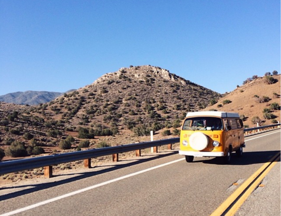 <span class="caption">Yellow van driving on the open road with mountains in the background.</span> <span class="attribution"><span class="source">#fosterhunting/Instagram</span></span>