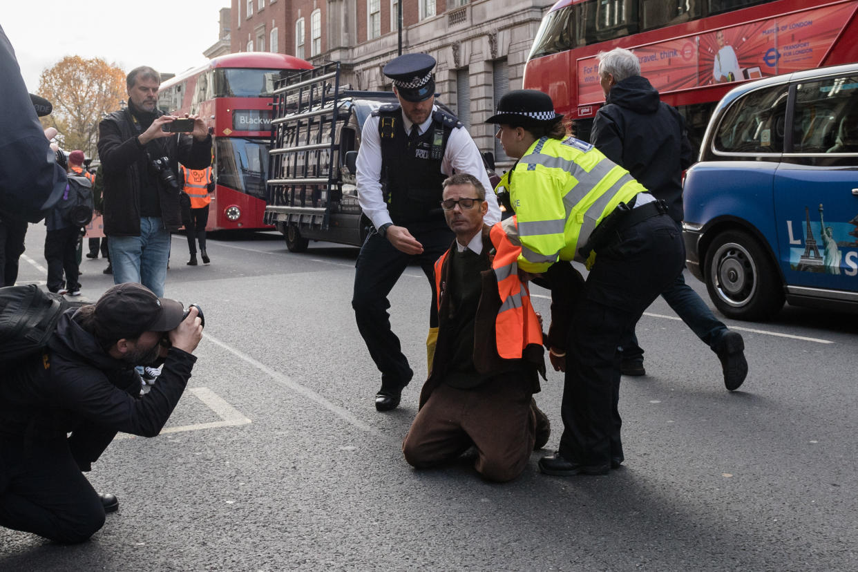 Police officers arrest environmental activists from Just Stop Oil. (Future Publishing via Getty Images)