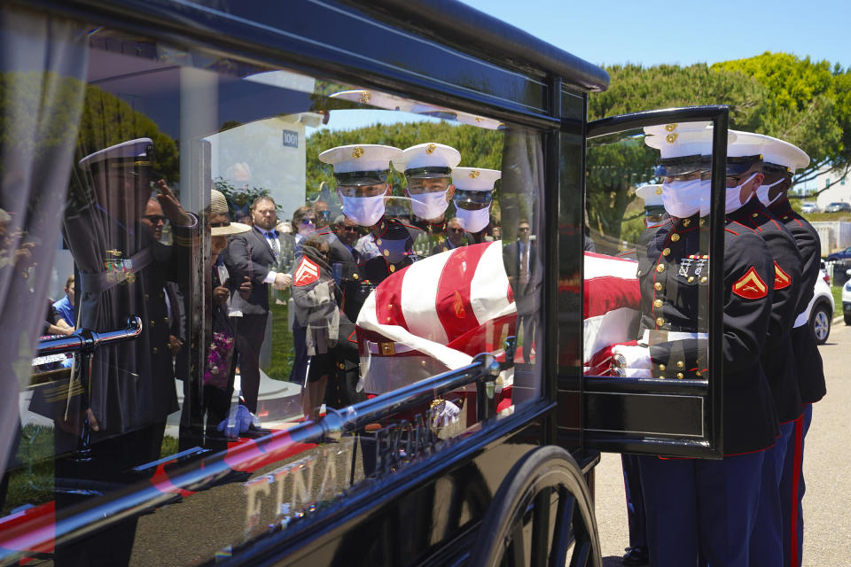 A Marine team places U.S. Marine Corps, Pfc. John Franklin Middleswart casket onto the horse-drawn funeral carriage where it will escorted to the ceremony for full military honors at Fort Rosecrans National Cemetery on Tuesday, June 8, 2021, in San Diego. Eighty years after he died in the attack on Pearl Harbor and just months after his remains were finally identified, the California Marine has been laid to rest with full military honors. (Nelvin C. Cepeda/The San Diego Union-Tribune via AP)