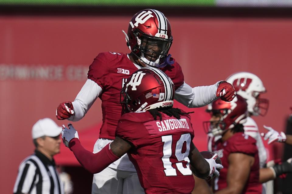 Indiana defensive back Josh Sanguinetti (19) celebrates a fumble recovery with defensive back Kobee Minor (5) during the second half of an NCAA college football game against Wisconsin, Saturday, Nov. 4, 2023, in Bloomington, Ind. (AP Photo/Darron Cummings)