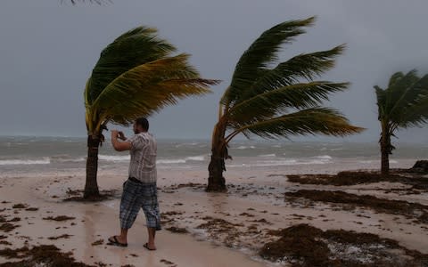 A man photographs the waves before the arrival of Hurricane Maria in Punta Cana - Credit: REUTERS/Ricardo Rojas