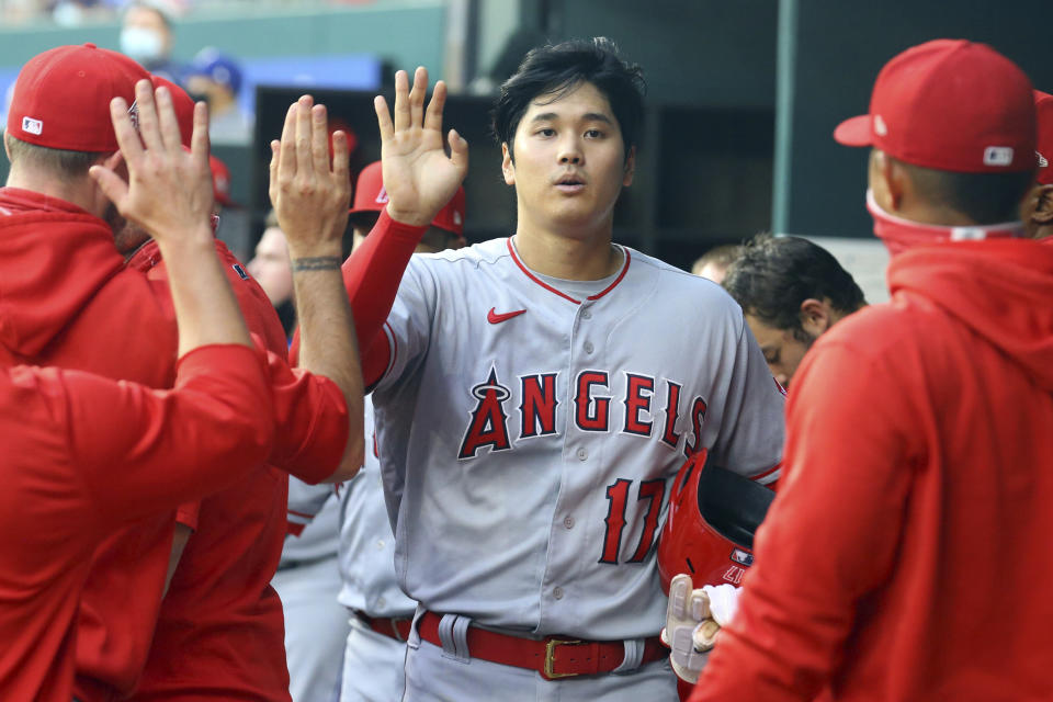 Los Angeles Angels starting pitcher Shohei Ohtani (17) is greeted in the dugout after scoring in the first inning during a baseball game against the Texas Rangers on Monday, April 26, 2021, in Arlington, Texas. (AP Photo/Richard W. Rodriguez)