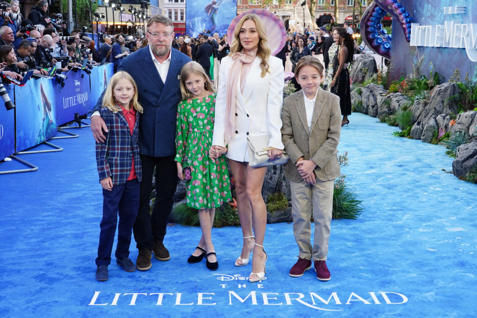 guy ritchie and his family pose on a red carpet