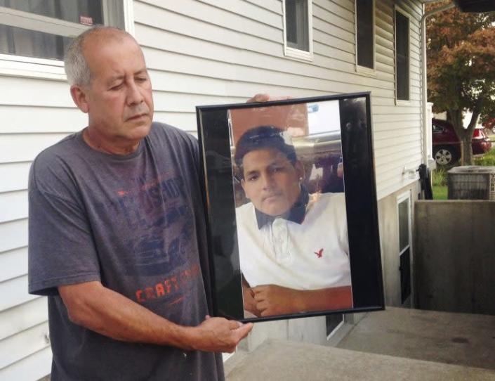 Abraham Chaparro with photograph of his murdered stepson, Miguel Garcia-Moran
