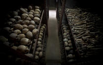 FILE - In this Friday, April 4, 2014 file photo, the skulls and bones of some of those who were slaughtered as they sought refuge inside the church, are laid out on shelves in an underground vault as a memorial to the thousands who were killed in and around the Catholic church during the 1994 genocide in Nyamata, Rwanda. France's role before and during 1994's Rwandan genocide was a "monumental failure" that the country must face, the lead author of a sweeping report commissioned by President Emmanuel Macron said, as the country is about to open its archives from this period for the first time to the broader public.(AP Photo/Ben Curtis, File)