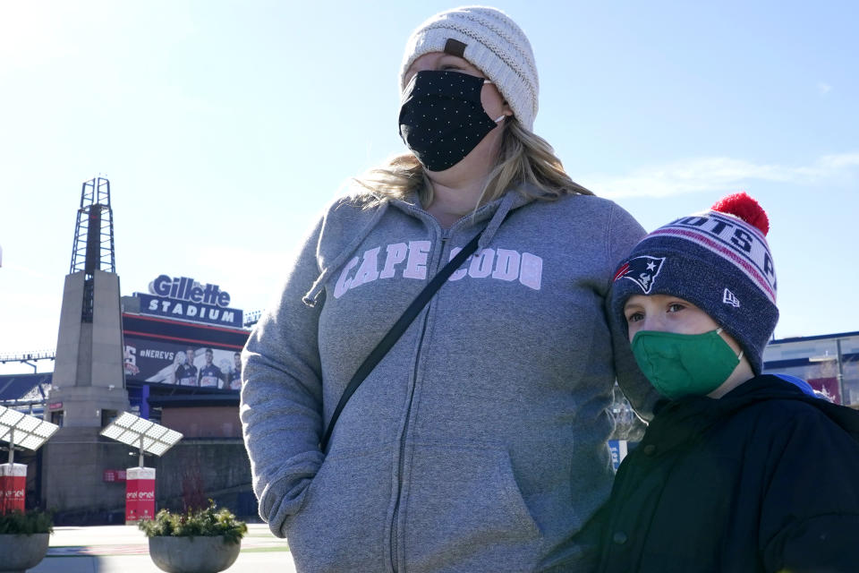 Kelly Roccabello and her son, Giovanni, 6, speak to a reporter outside the pro shop at Gillette Stadium, Monday Jan. 25, 2021, in Foxborough, Mass. Tom Brady is going to the Super Bowl for the 10th time, and New England Patriots football fans are cheering for him -- just like before. (AP Photo/Elise Amendola)