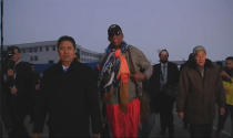 Retired U.S. basketball star Dennis Rodman (C) walks behind an official upon arriving in North Korea, in this still image taken from video released by North Korea's Korean Central News Agency (KCNA) in Pyongyang December 19, 2013. Rodman said on Thursday he was not going to North Korea to talk about politics or human rights, despite political tension surrounding the execution of leader Kim Jong Un's uncle. Rodman has visited Pyongyang twice before, spending time dining as a guest of Kim, with whom he says he has a genuine friendship. (REUTERS/KCNA for Reuters TV)