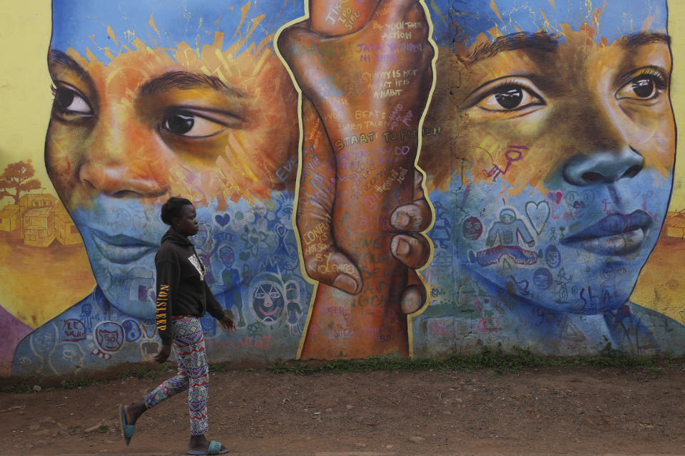 A woman walks past an informational mural against gender based violence, on a street in Nairobi, Kenya, Wednesday, March 6, 2024. Globally, one in three women experiences either intimate partner violence or non-partner sexual violence during their lifetime, according to the World Health Organization.(AP Photo/Brian Inganga)