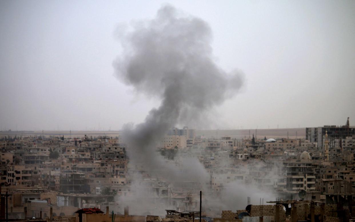 Smoke rises from buildings in a rebel-held neighbourhood of Daraa in southern Syria following reported shelling - AFP