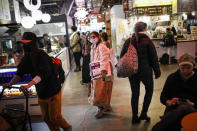 Shoppers wear masks while carrying their groceries out of a supermarket, Thursday, March 12, 2020, in the Brooklyn borough of New York. Mayor Bill de Blasio said Thursday he will announce new restrictions on gatherings to halt the spread of the new coronavirus in the coming days, but he hopes to avoid closing all public events such as Broadway shows. The vast majority of people recover from the new coronavirus. According to the World Health Organization, most people recover in about two to six weeks, depending on the severity of the illness. (AP Photo/John Minchillo)