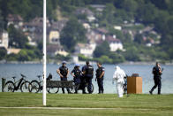 Security forces examine the scene of knife attack in Annecy, French Alps, Thursday, June 8, 2023. An attacker with a knife stabbed several young children and at least one adult, leaving some with life-threatening injuries, in a town in the Alps on Thursday before he was arrested, authorities said. (Jean-Christophe Bott/Keystone via AP)