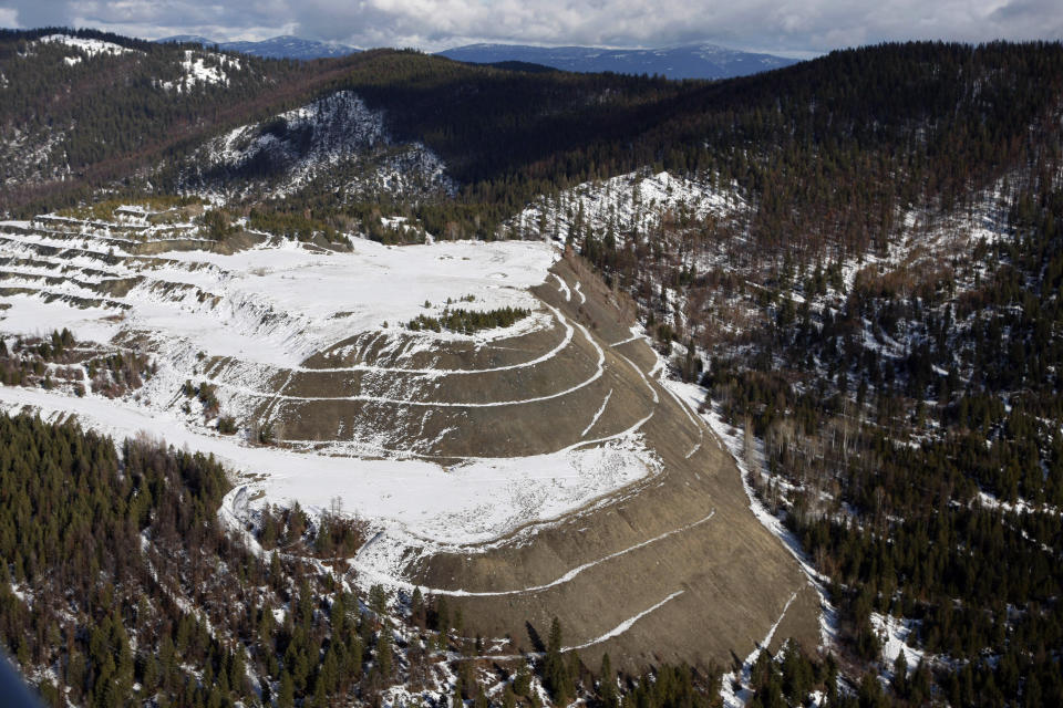 FILE - The W.R. Grace vermiculite mine is shown, outside of Libby, Mont., Feb. 17, 2010. Libby, a town of about 3,000 along the Kootenai River, had widespread contamination from asbestos-tainted vermiculite that was stored in town and transported by rail across the U.S. for use as insulation and other purposes. Contamination in the town has been cleaned up but the mine has not been addressed. (AP Photo/Rick Bowmer, File)