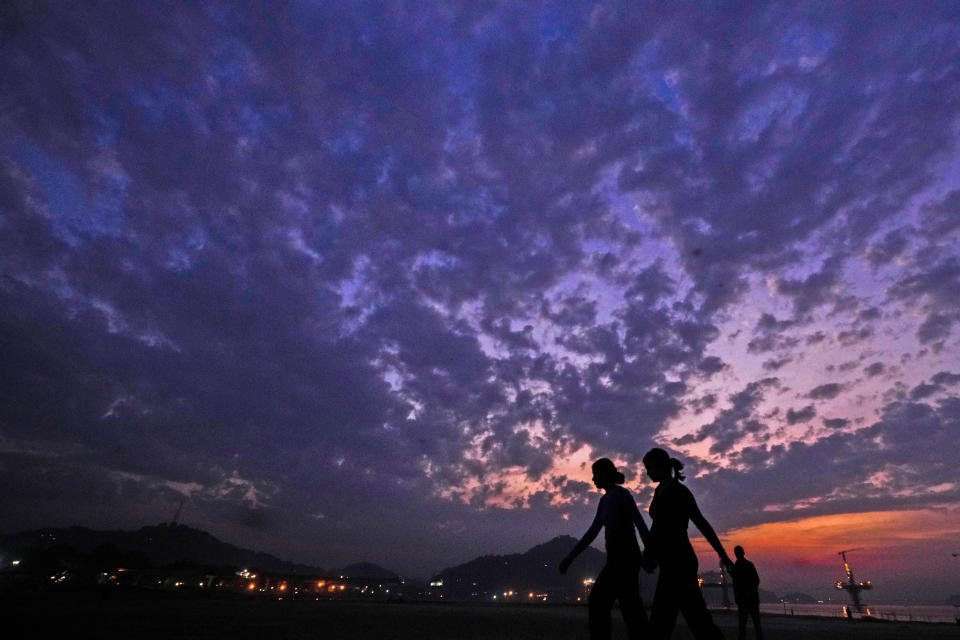 Women walk along the river Brahmaputra during twilight hour in Guwahati, India, Monday, Dec. 18, 2023. (AP Photo/Anupam Nath)