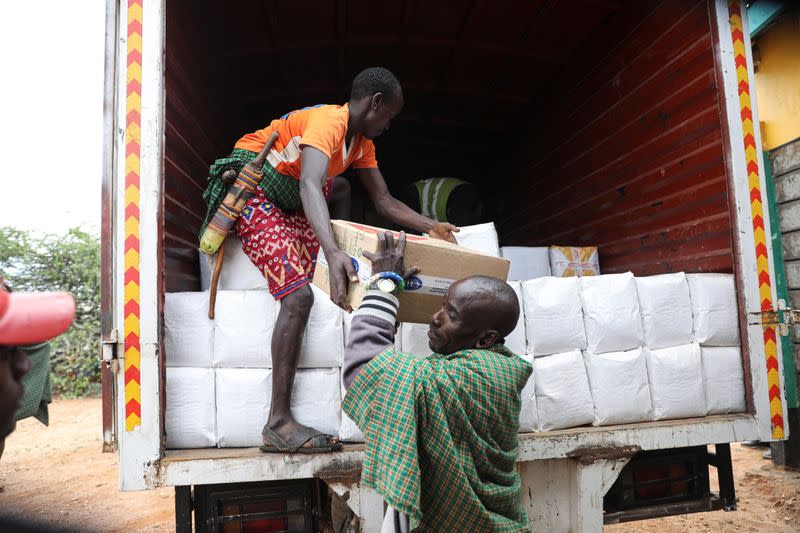 Men cary food destination given as a relief due to an ongoing drought, in the town of Oldonyiro, Isiolo county