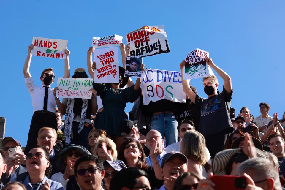 Demonstrators hold up signs as a second pro-Palestine protest interrupts the UC Berkeley Law School (ONLINE_YES)