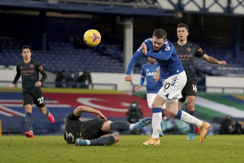 Everton's Gylfi Sigurdsson, 10, has a shot on goal blocked by Manchester City's Ruben Dias, bottom, during the English Premier League soccer match between Everton and Manchester City at Goodison Park stadium, in Liverpool, England, Wednesday, Feb. 17, 2021. (Jon Super/Pool via AP)